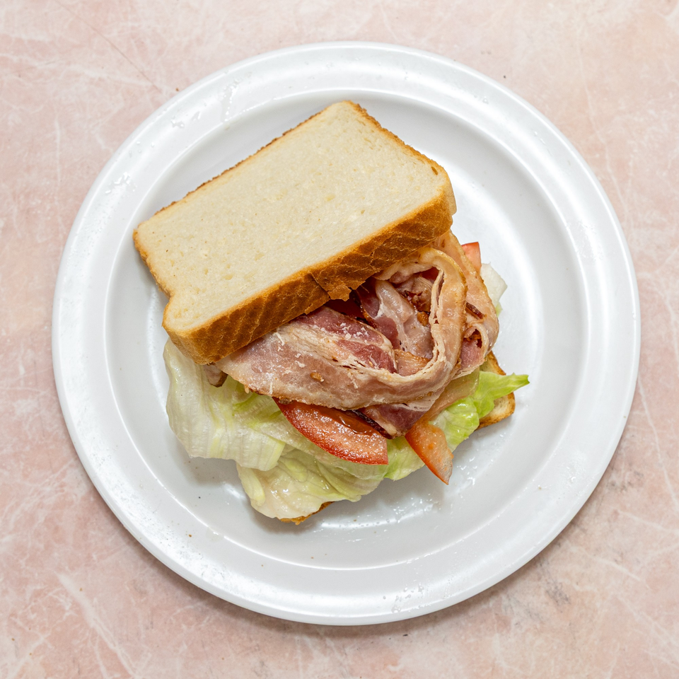 Classic BLT sandwich with crispy bacon, fresh lettuce, and sliced tomatoes on white toast.